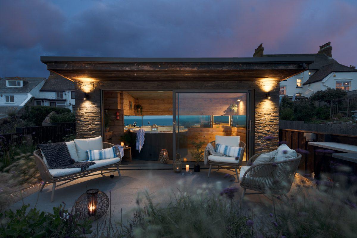 Summer house and terrace photographed at dusk. Professionally styled on location in Cornwall.