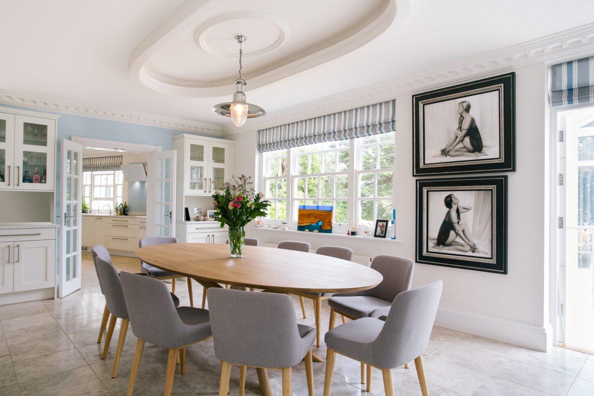 Elegant dining room leading to contemporary kitchen in a large waterside home in Cornwall.