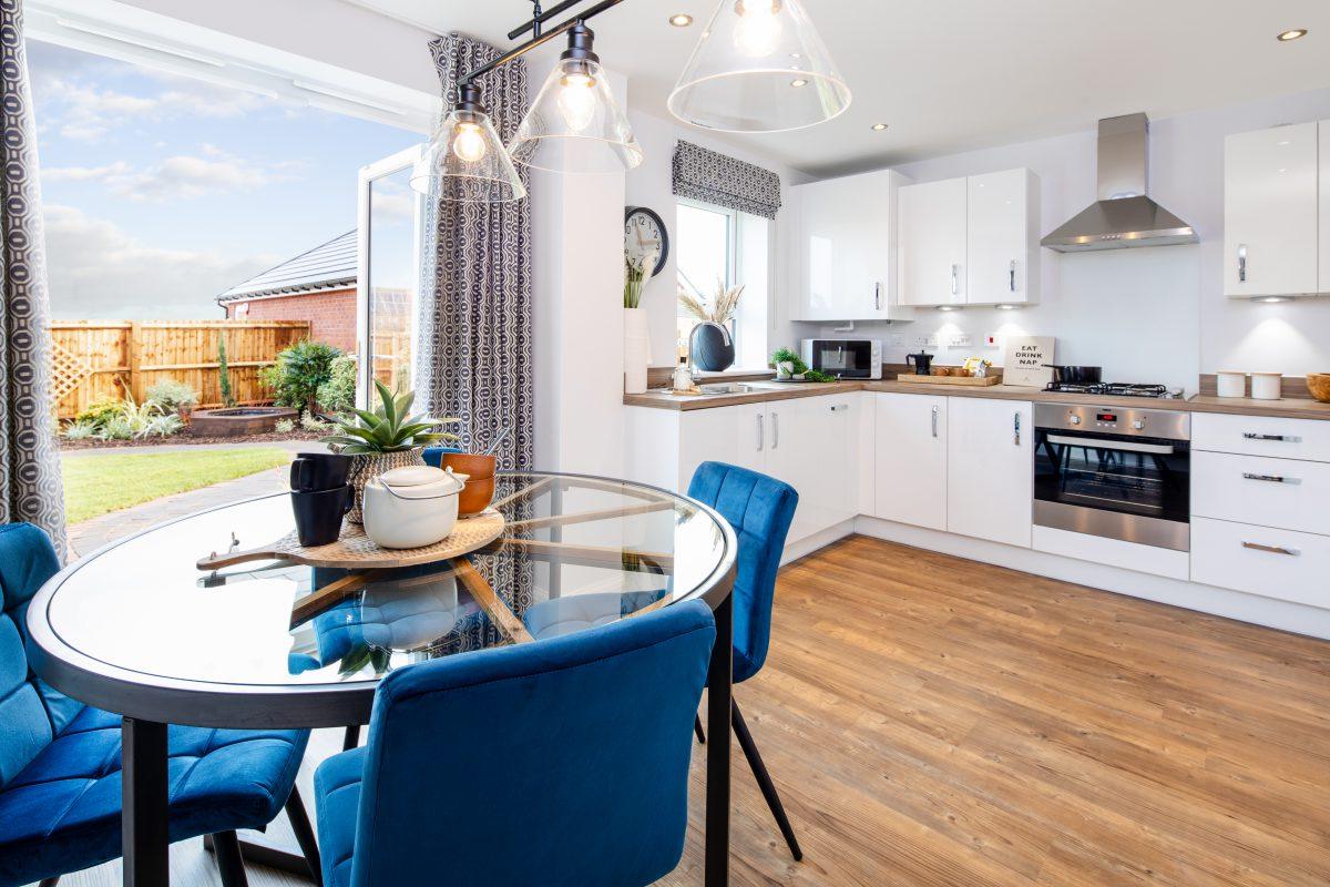 Open plan kitchen dining room in showhome of new housing development.