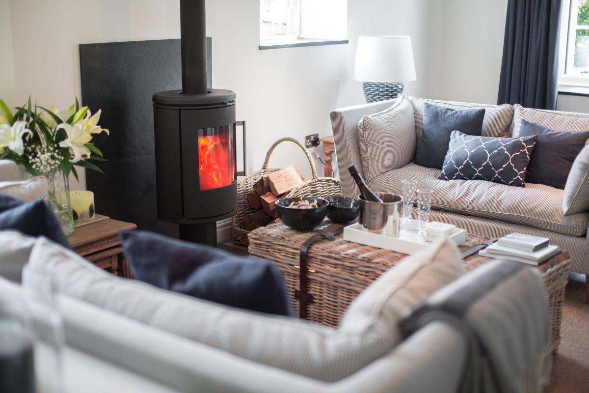 Interior photograph for a holiday rental property in Cornwall. Snacks on the coffee table and wood buring stove in the background.