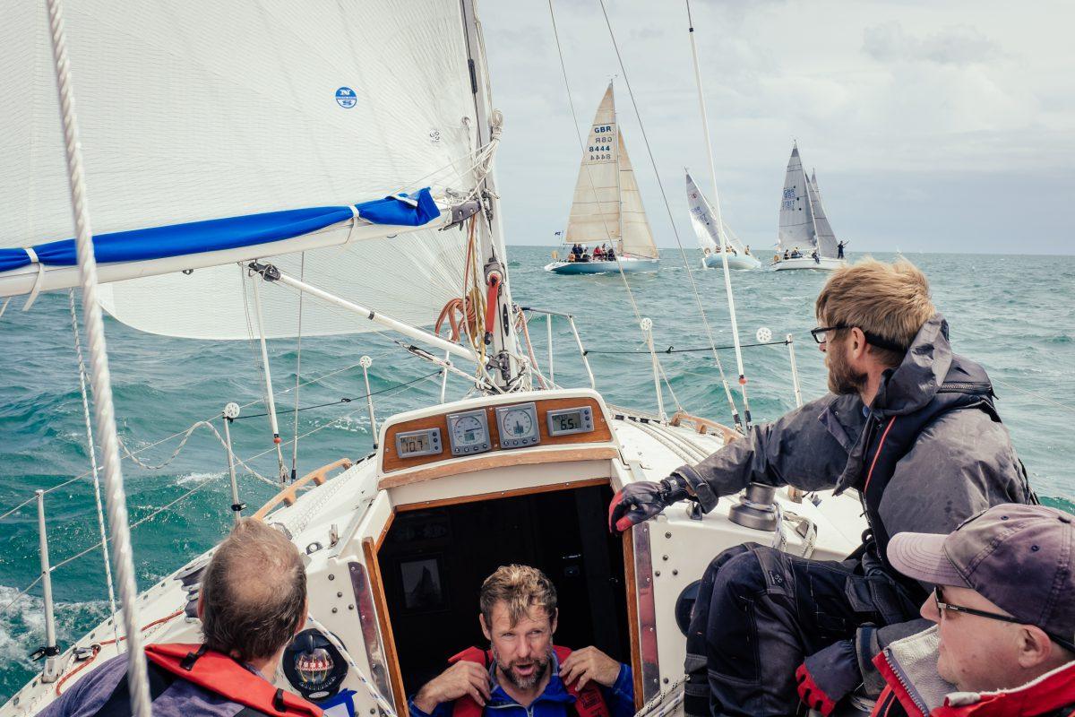 A group of sailors aboard a boat mid-race in the Falmouth area in Cornwall.