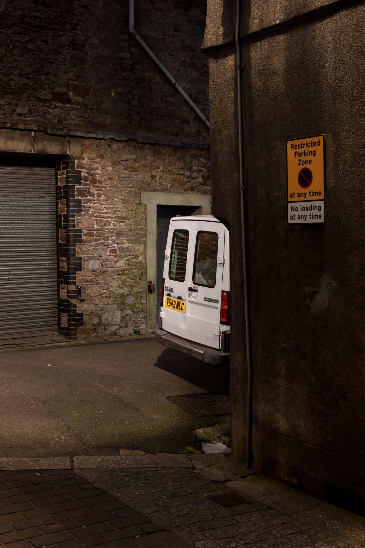 A car parked in a narrow street in Brixham, Devon. Shot in low light.